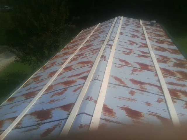 Rusted metal roof panels with new wood purlins before replacement — Storm Damage Roof Repair in Beech Bluff by Roofing Brothers