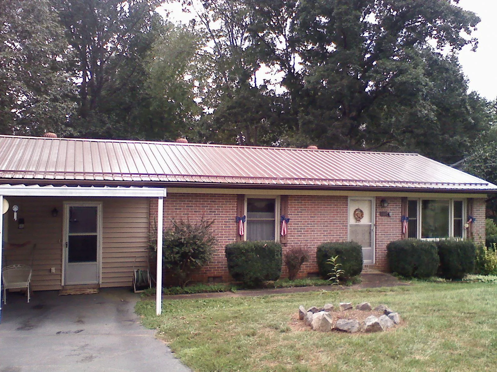 Bronze metal roof and carport on a brick ranch home — Roof Repair work by our crew in Beech Bluff